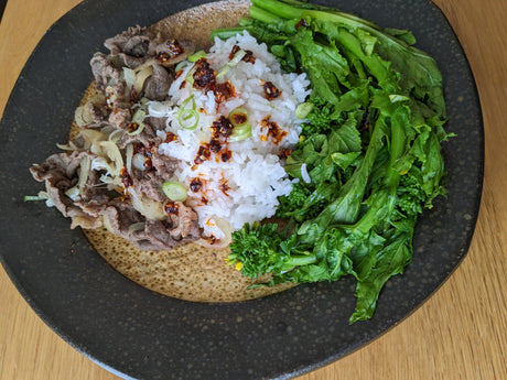 Thin sliced beef served with rice, topped with chili oil and scallion