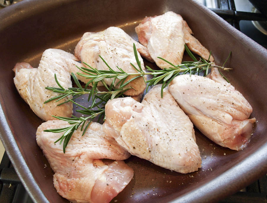 Organic Pastured chicken wings arranged in a shallow ceramic dish.